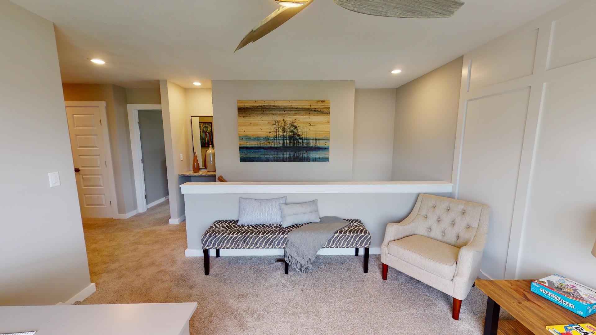 flex space with ceiling fan and pony wall