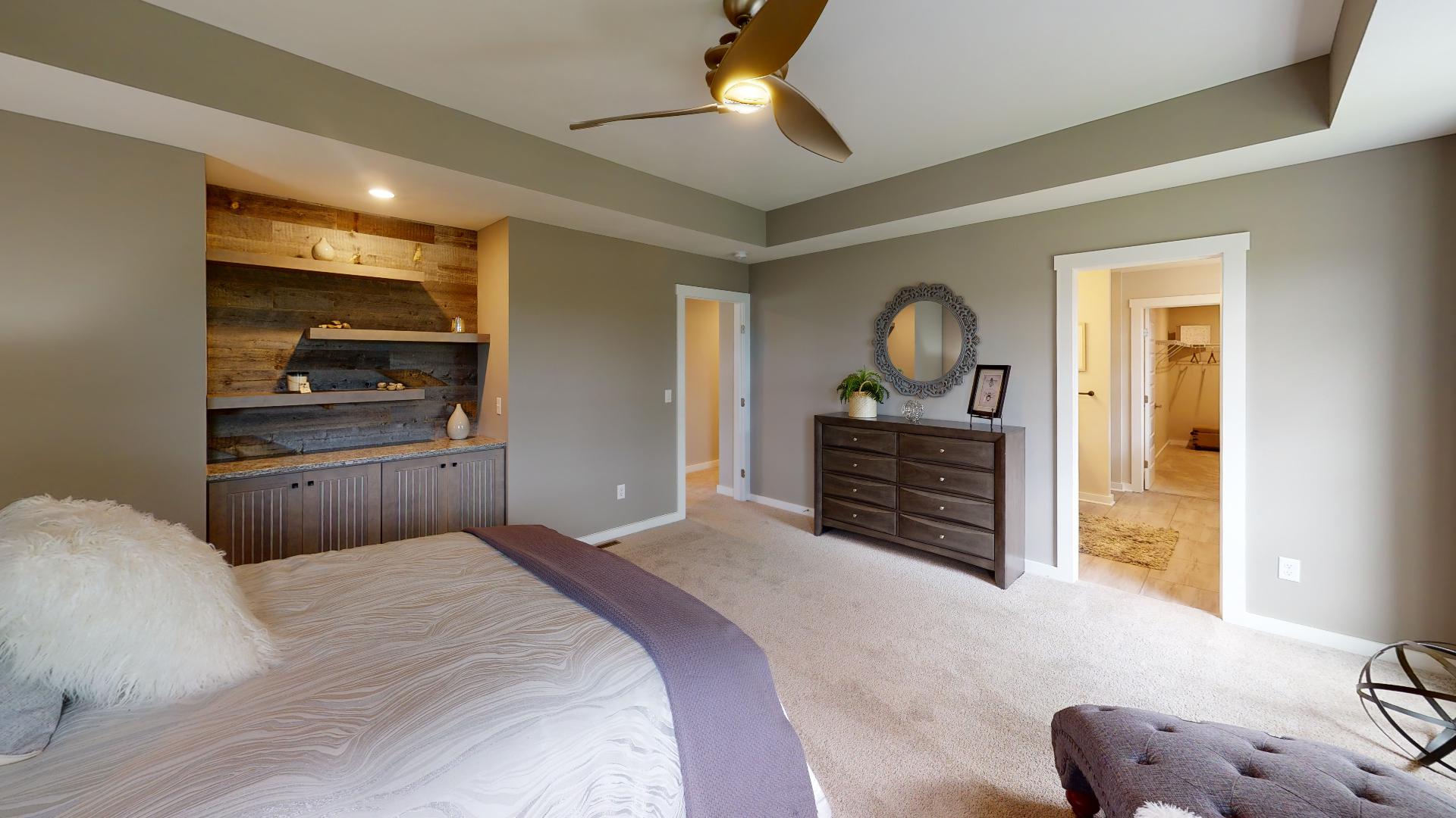 primary bedroom with built-in shelves and ensuite bathroom