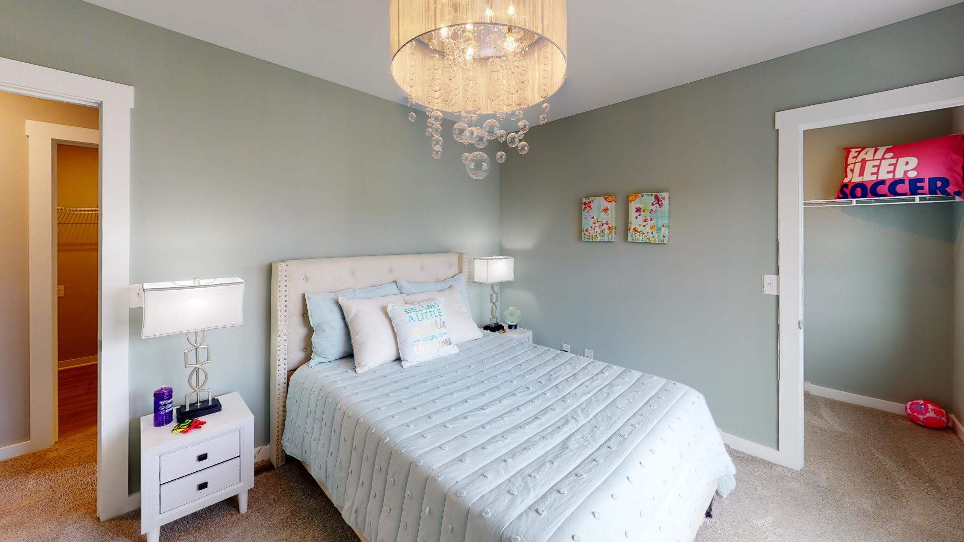 bedroom with bubble light fixture and walk-in closet