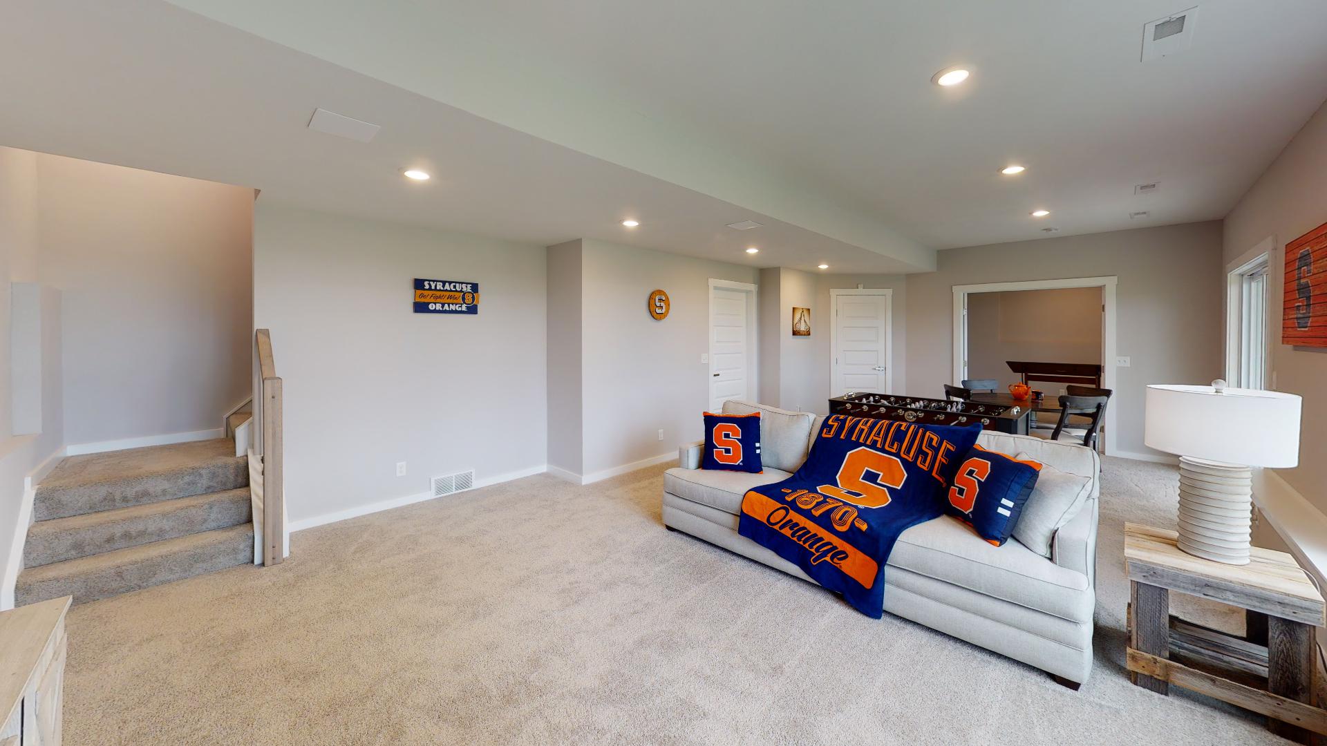 stairs and flex room with couch and table set