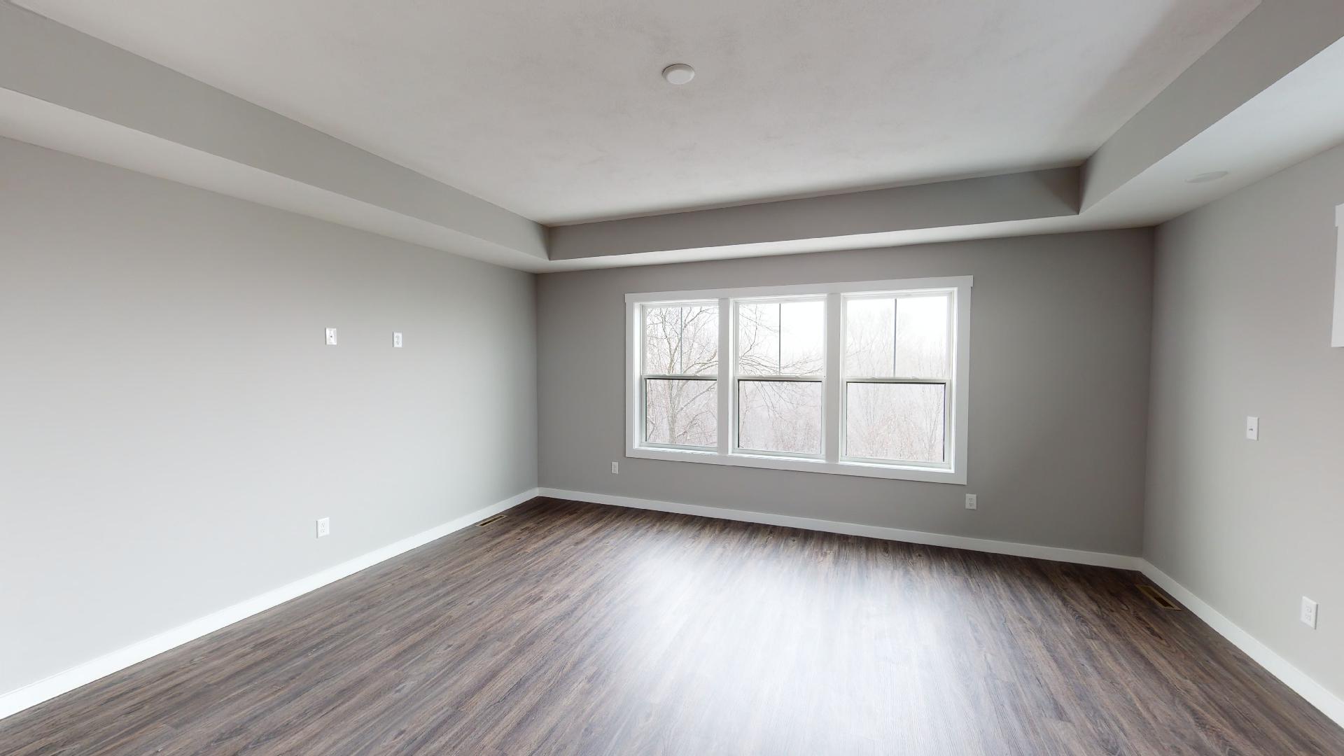 primary bedroom with recessed ceiling