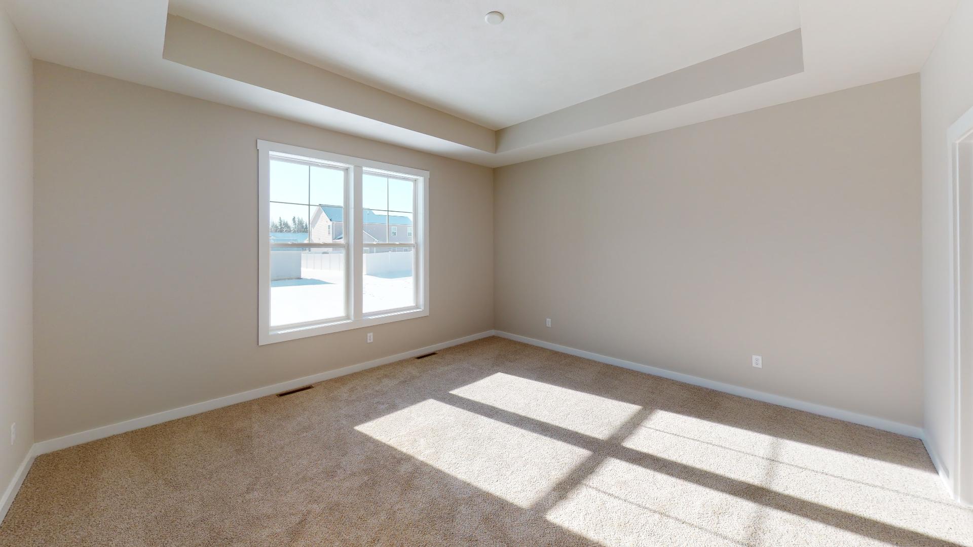 primary bedroom with recessed ceiling