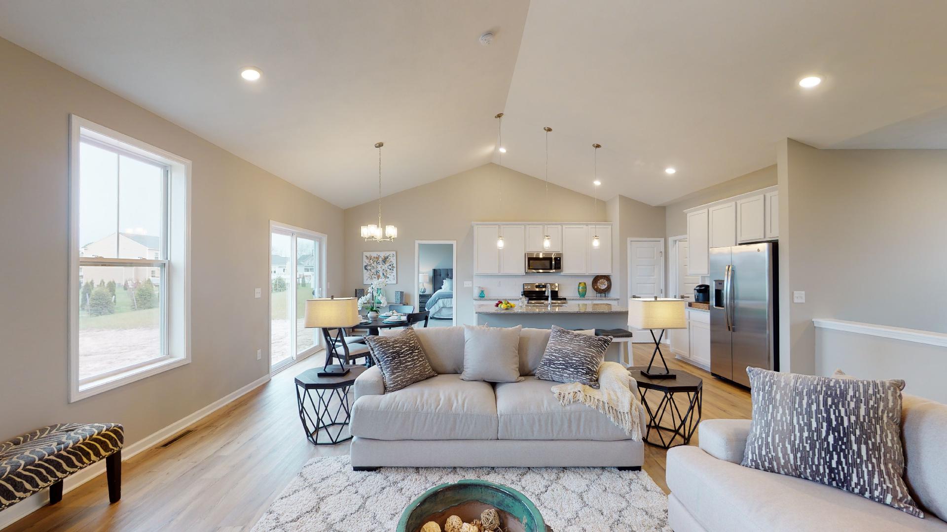 living room and kitchen in background with vaulted ceiling