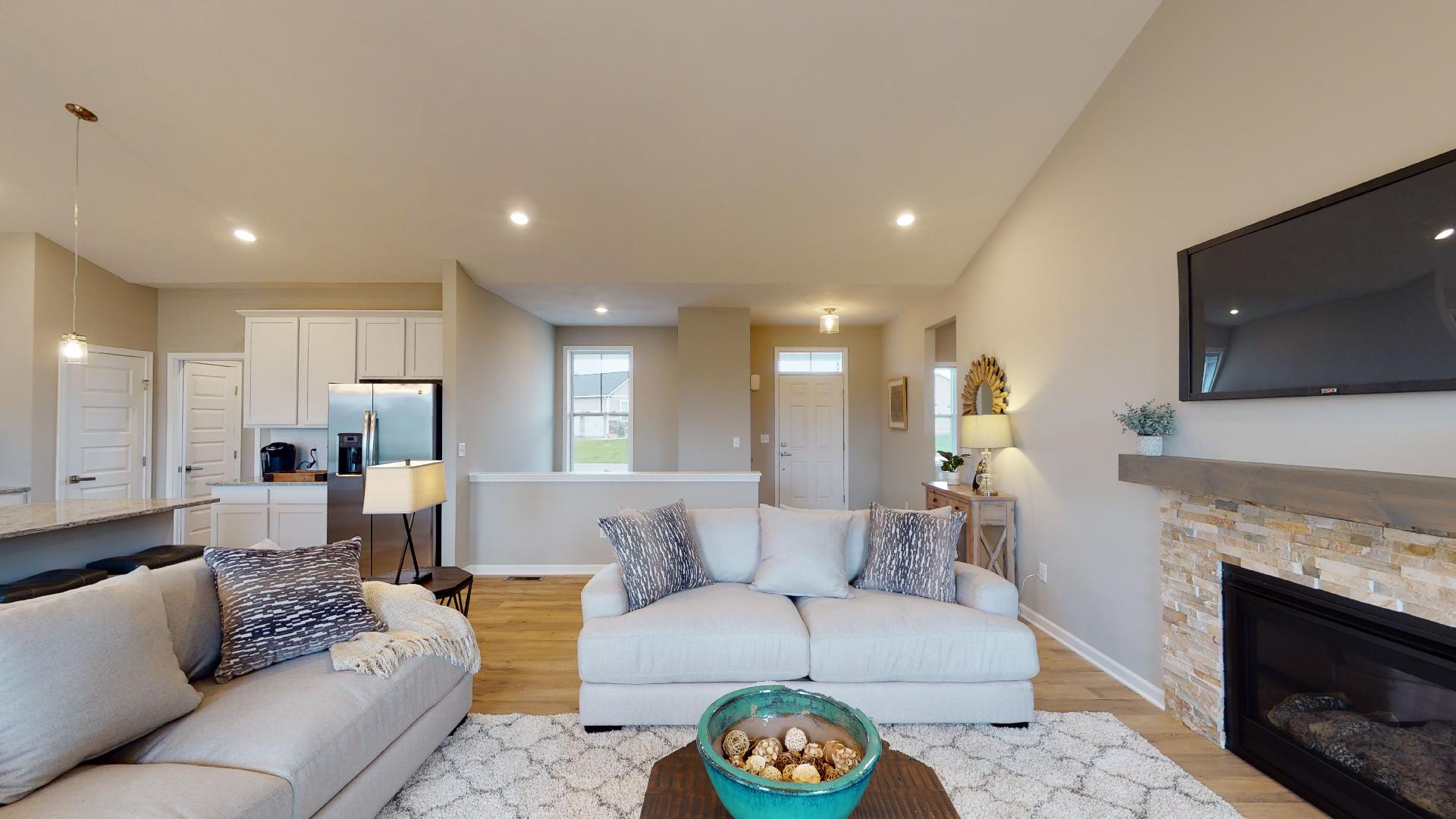 living room with kitchen and front entryway in background