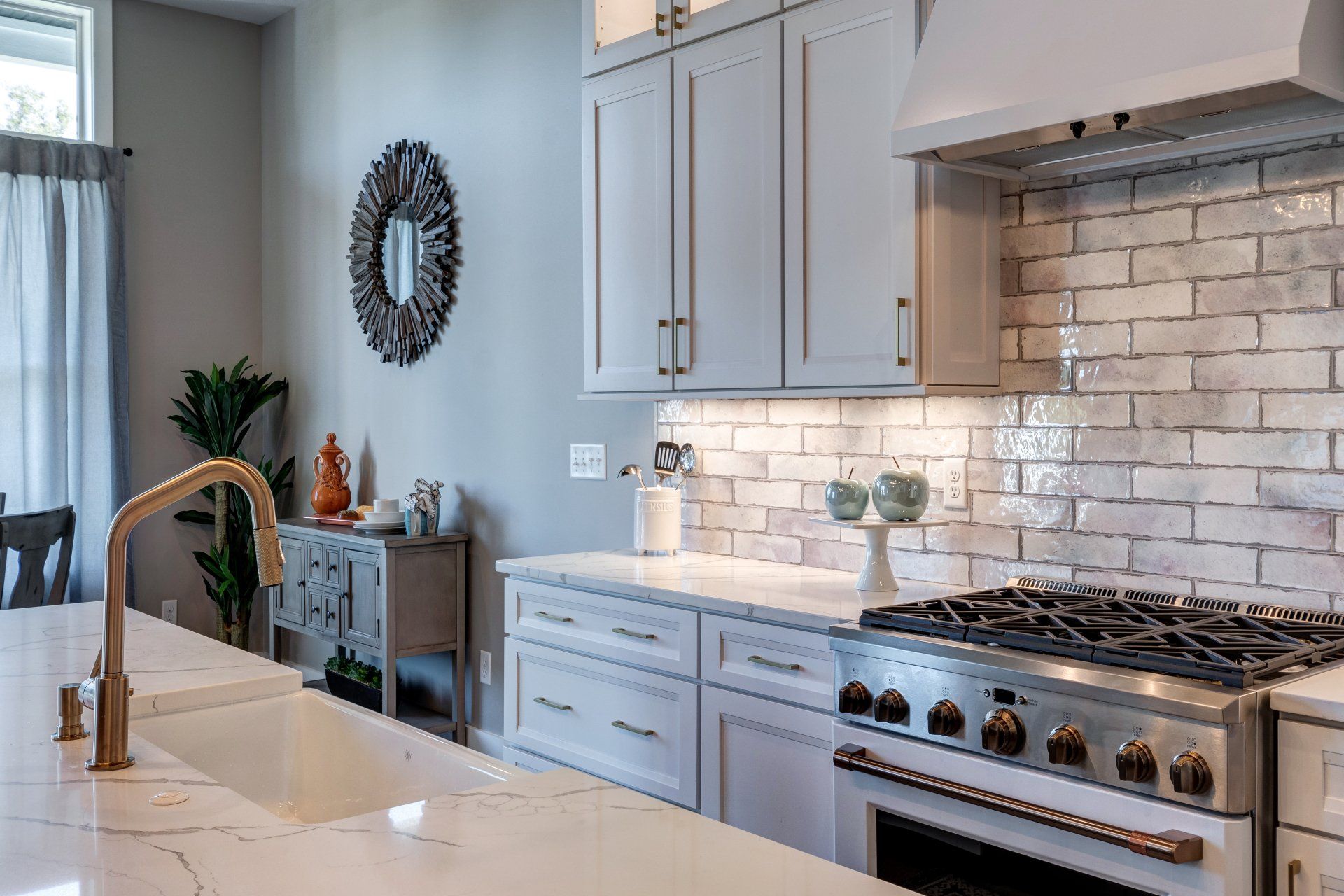 gas range and range hood and brick pattern backsplash