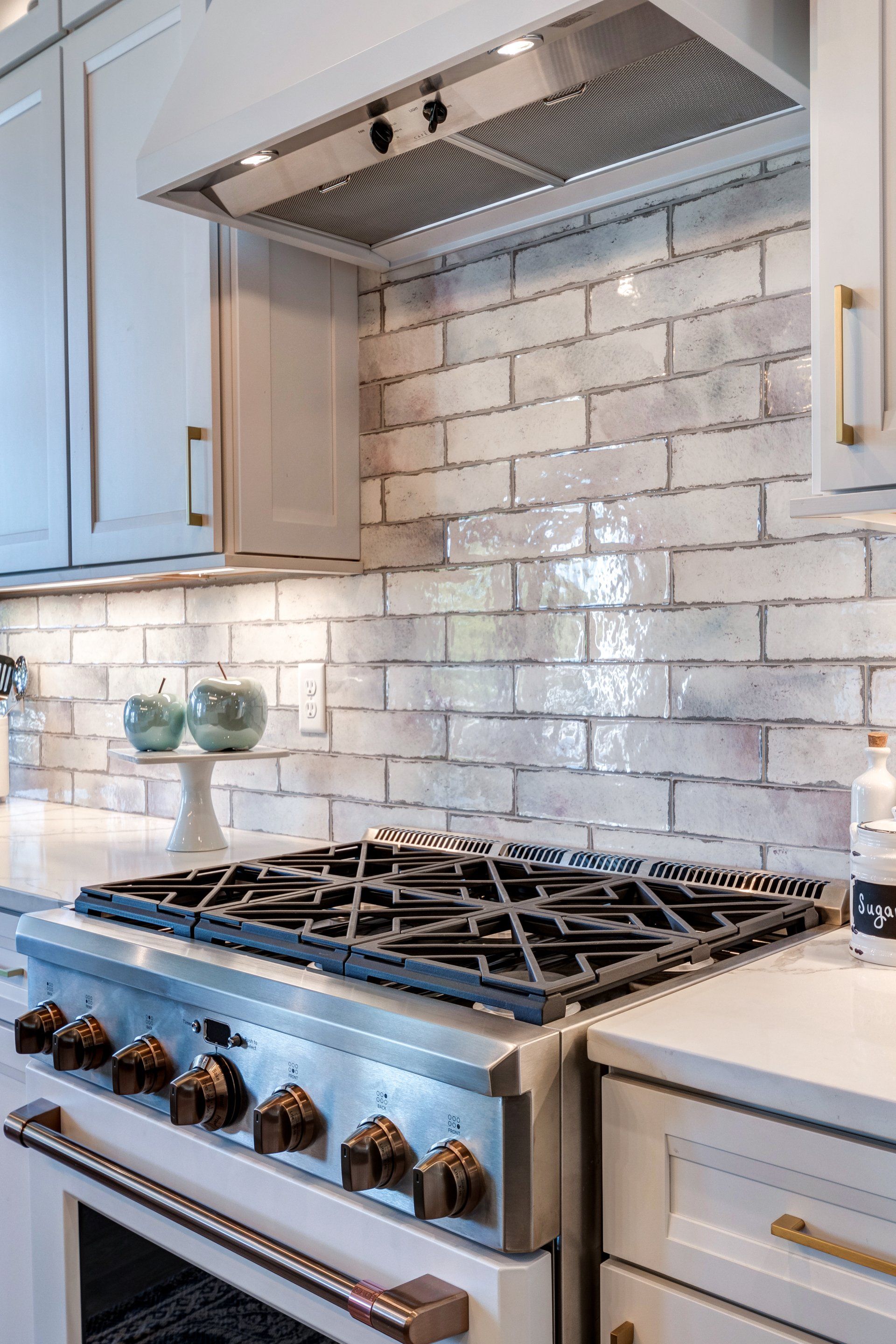 gas range and range hood and brick pattern backsplash