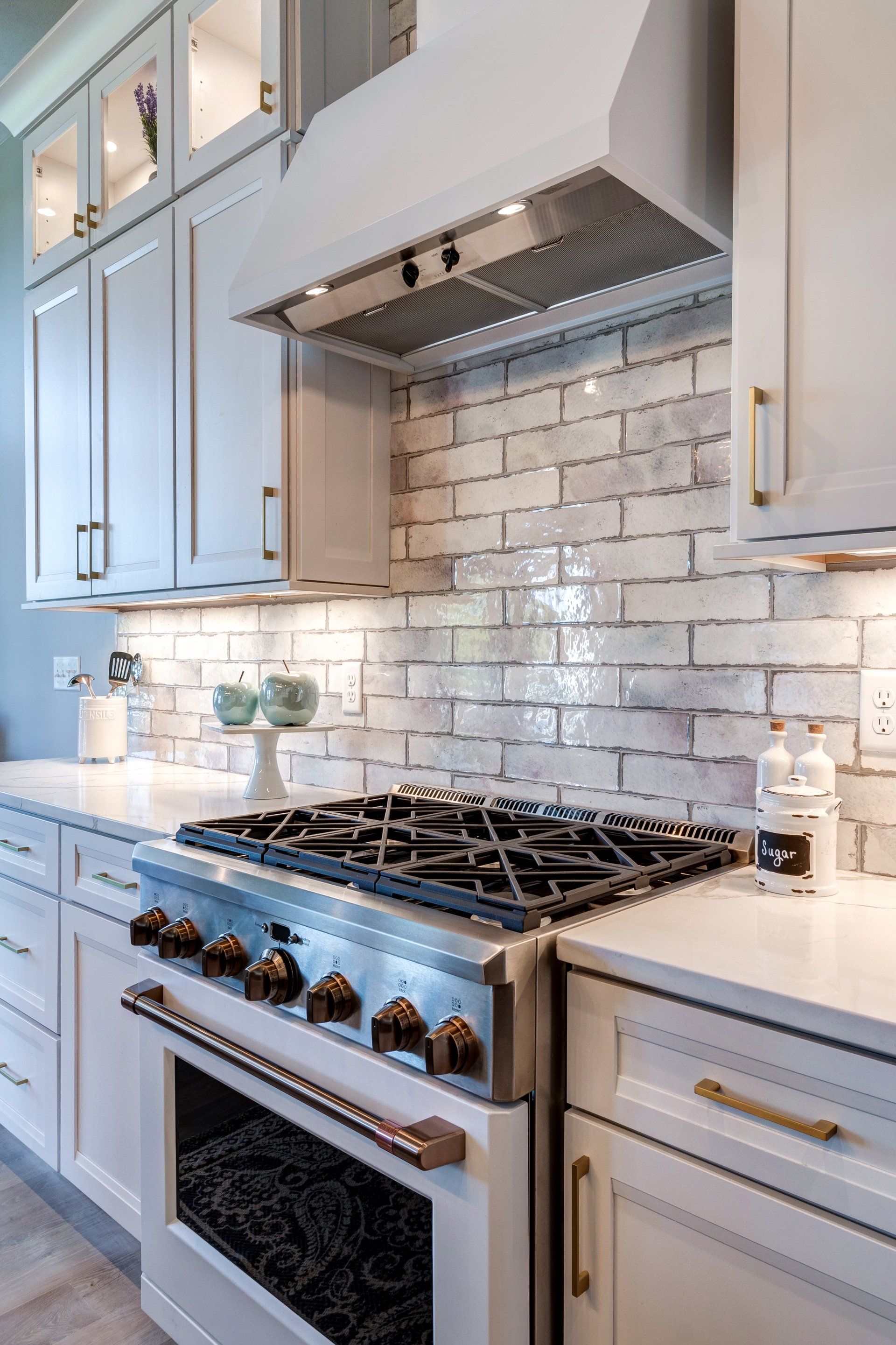 gas range and range hood and brick pattern backsplash