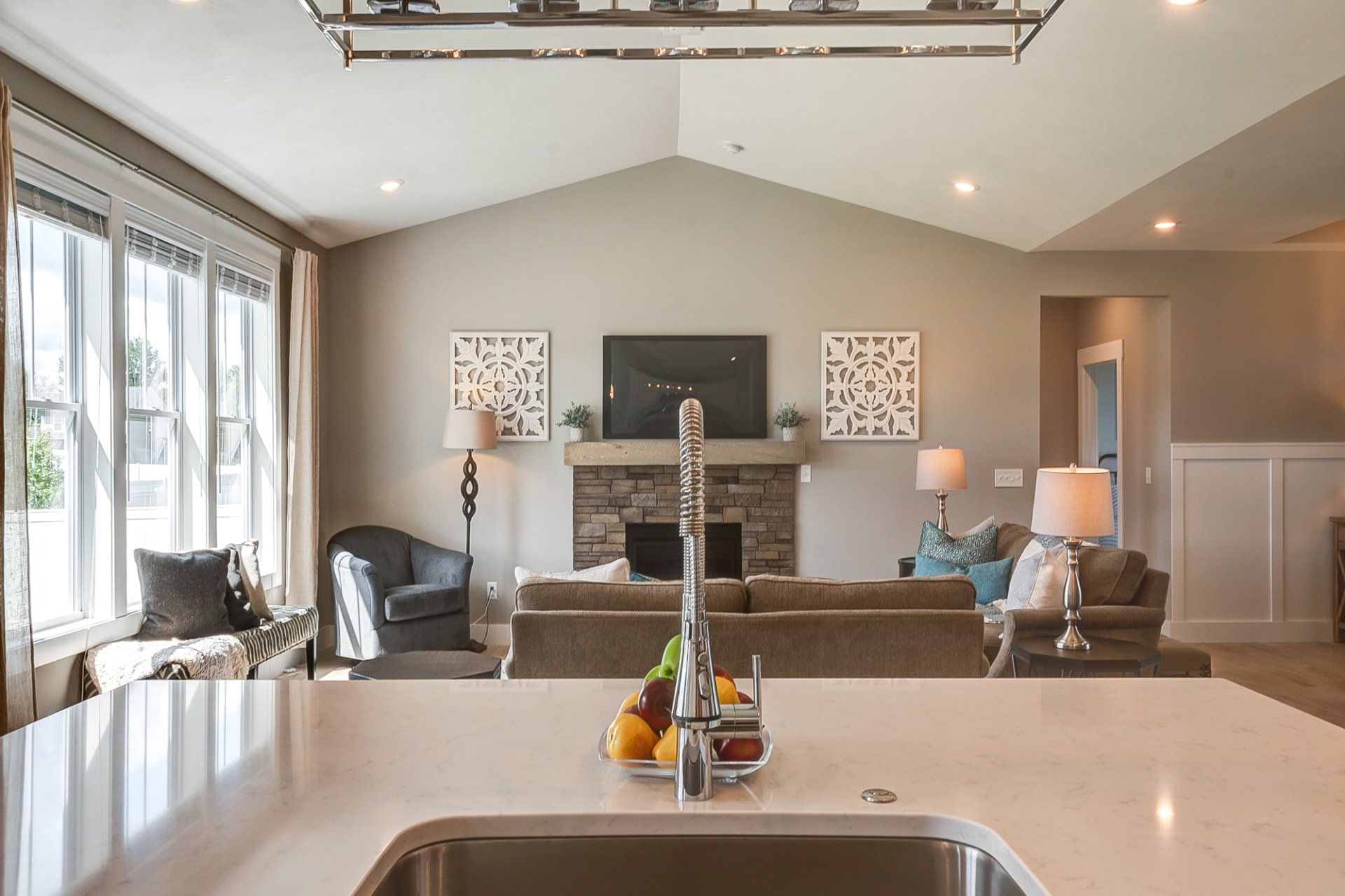 kitchen island with sink and dishwasher looking out into living room