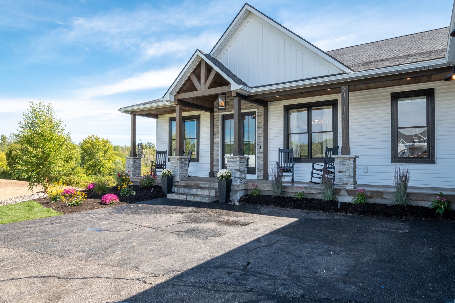 driveway and covered front porch with rocking chairs