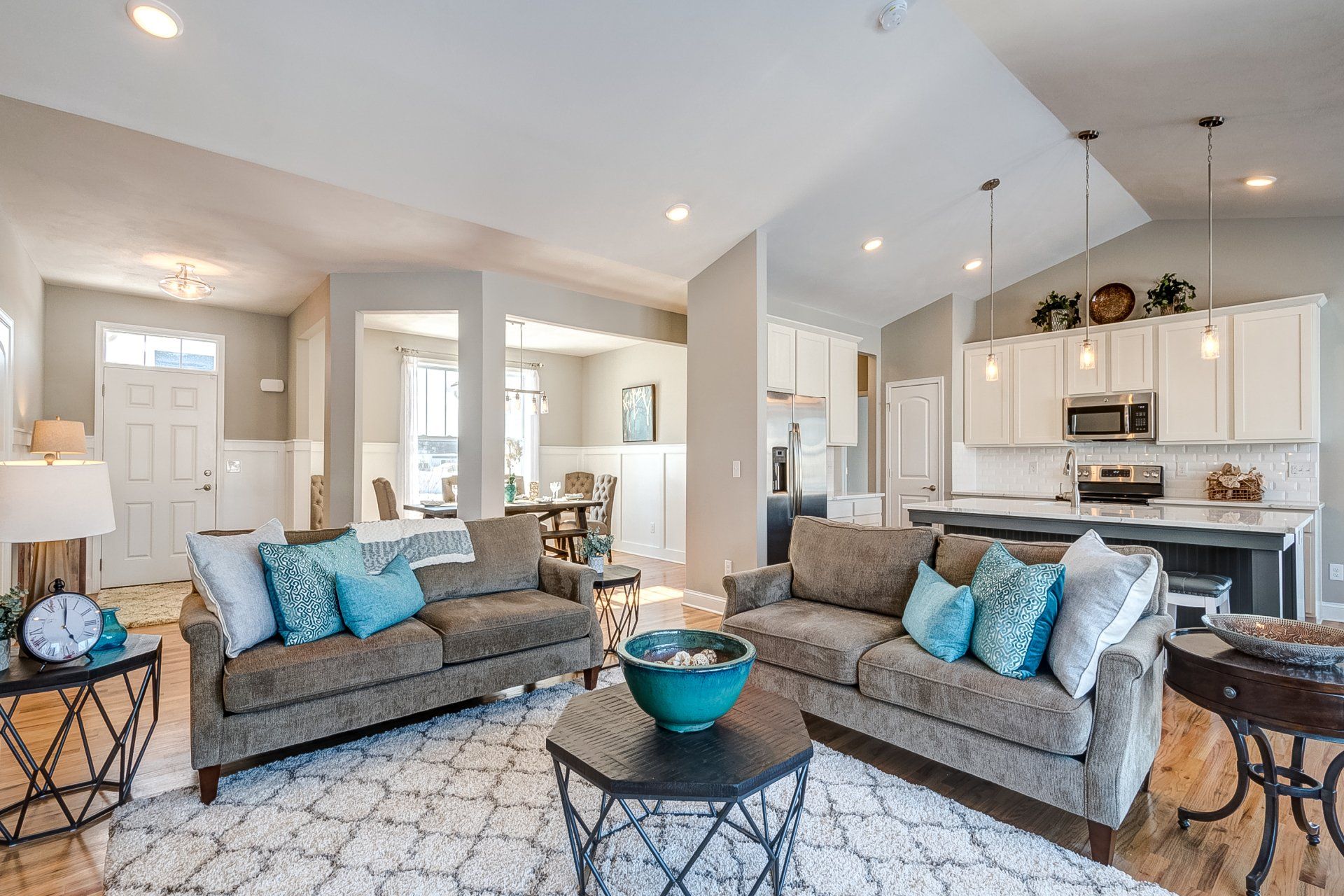 living room with front entryway, dinning room, and kitchen in background