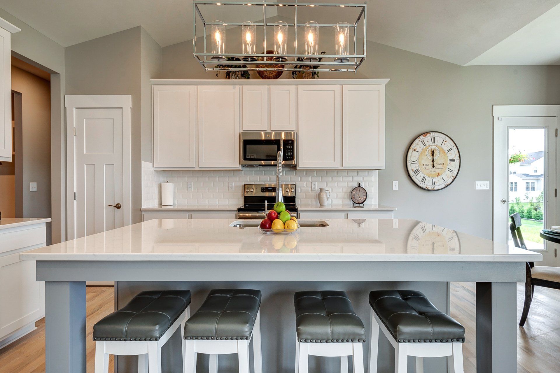 light fixture over island with sink and seating