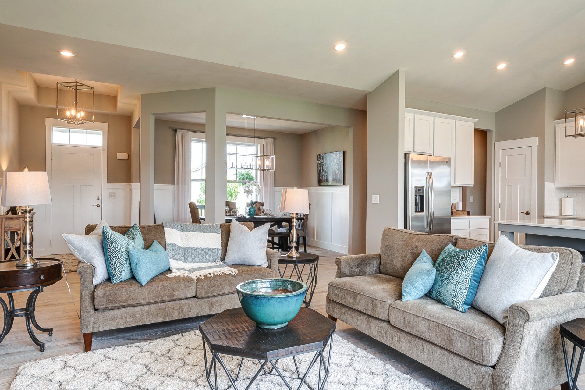 living room with front entryway, dining room, and kitchen in background