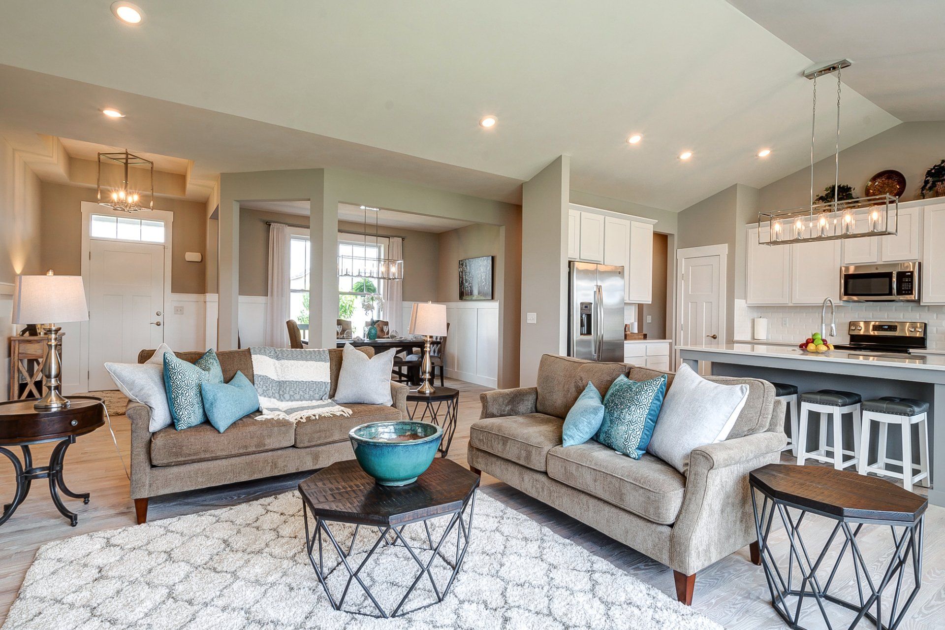 living room with front entryway, dining room, and kitchen in background