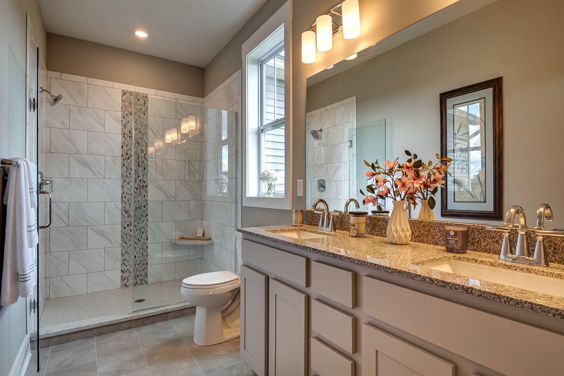 primary bathroom with double vanity and tile shower