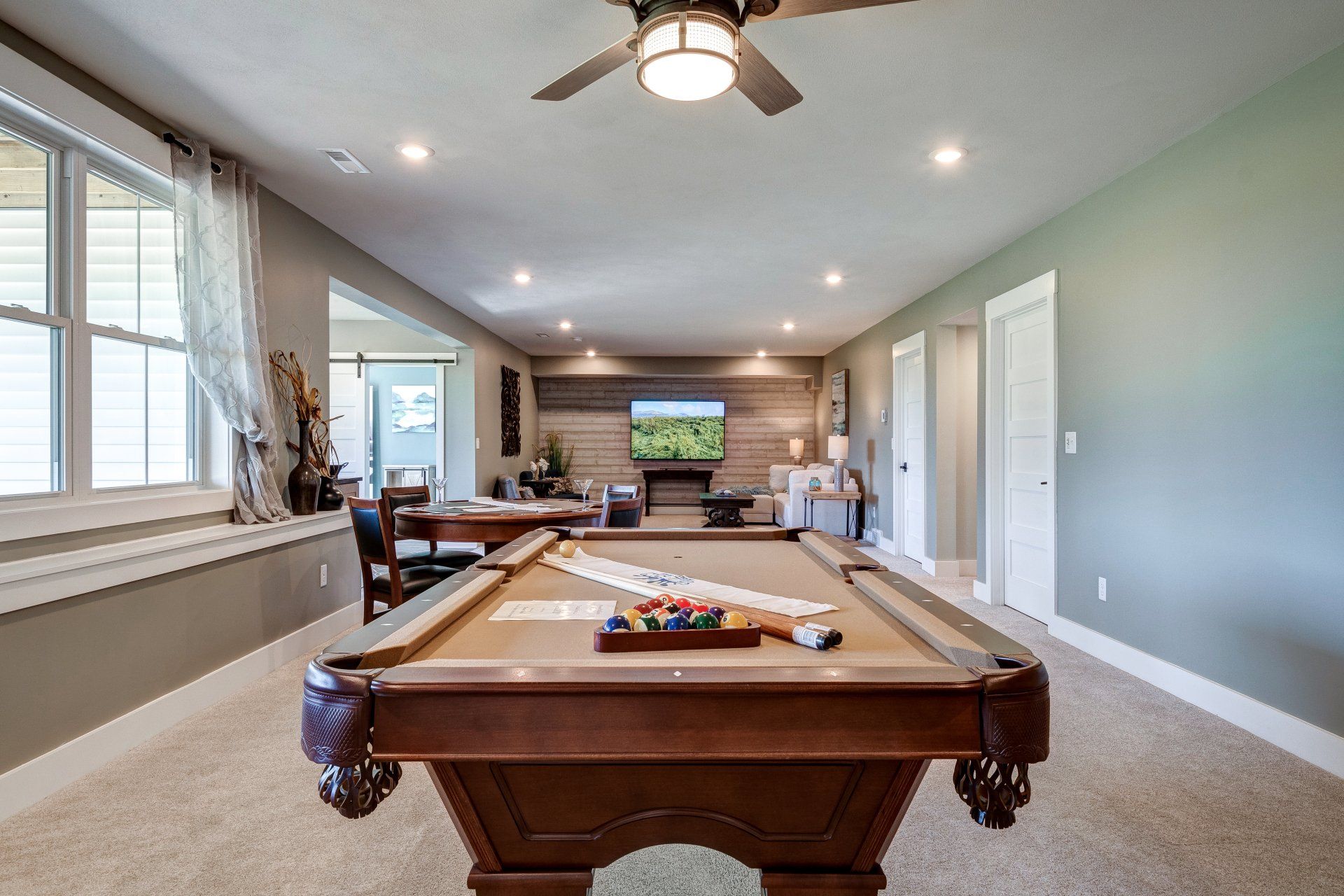 pool table with poker table and living area in background