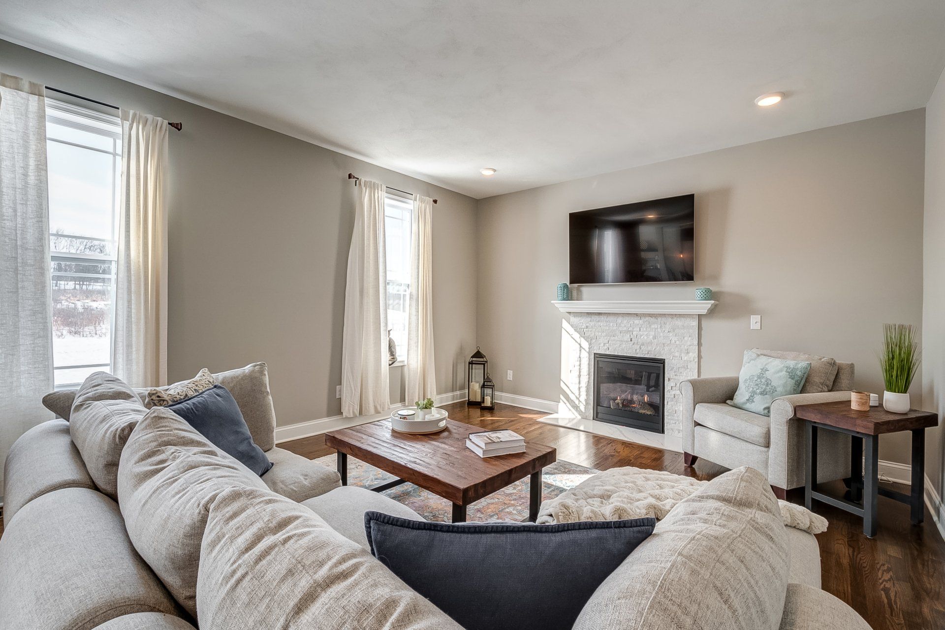 living room with sectional, coffee table, and fireplace