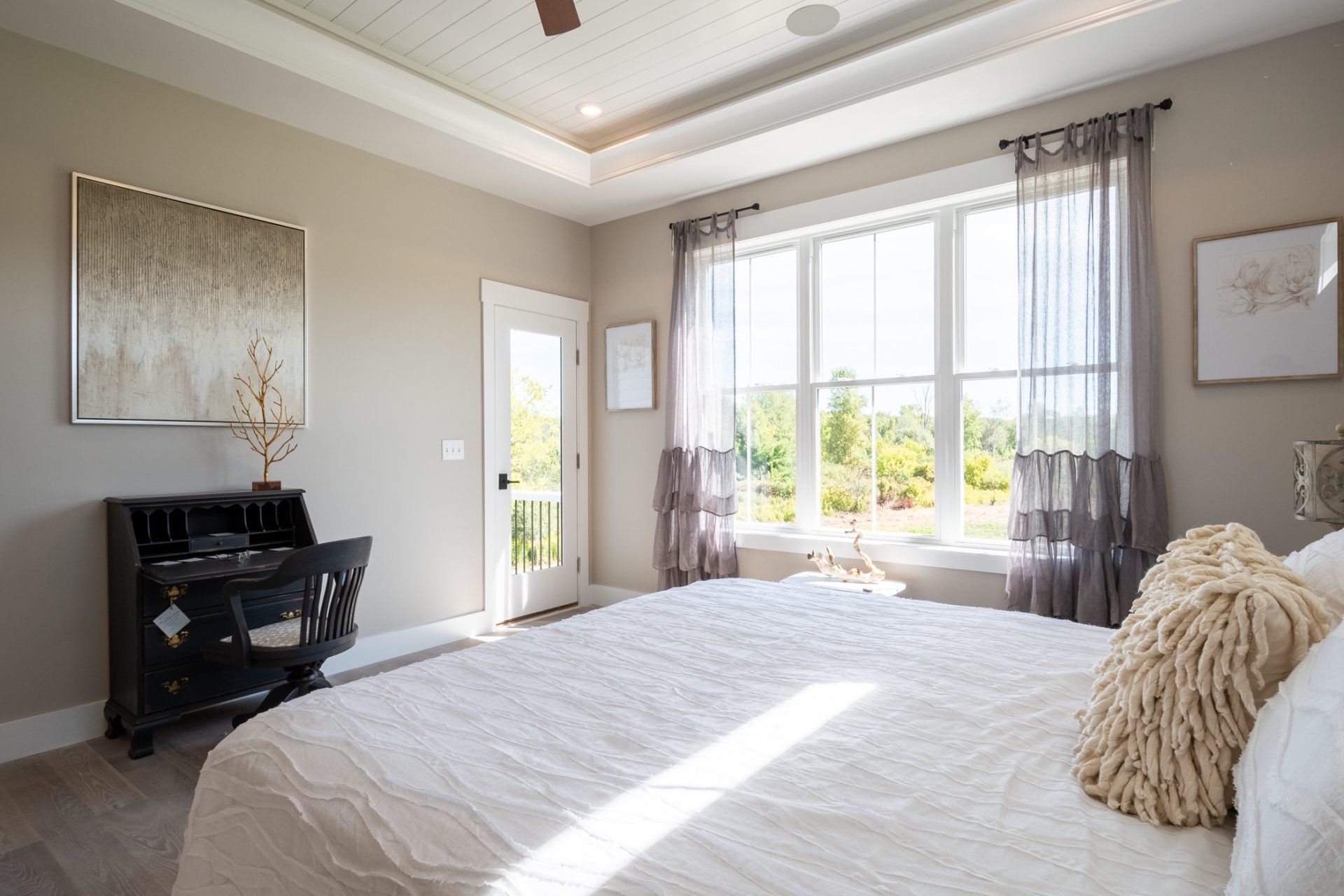 primary bedroom with recessed ceilings and ceiling fan