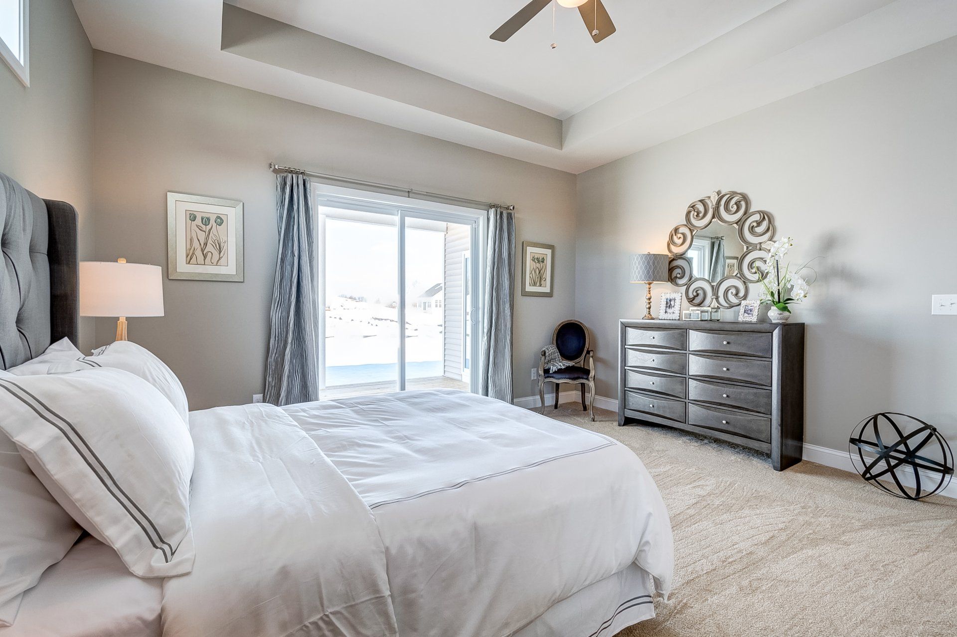 primary bedroom with recessed ceiling and patio access