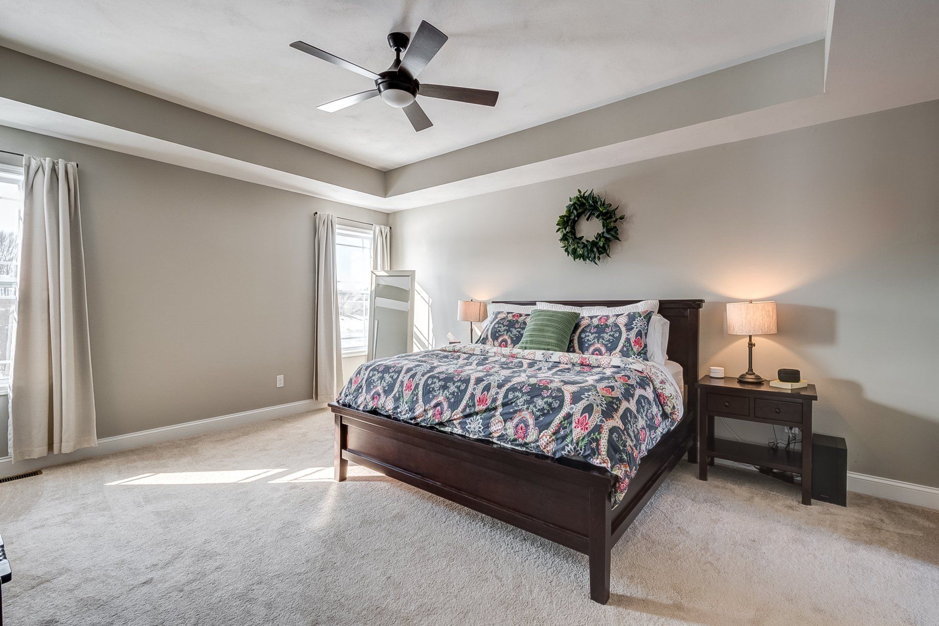 primary bedroom with recessed ceilings and ceiling fan