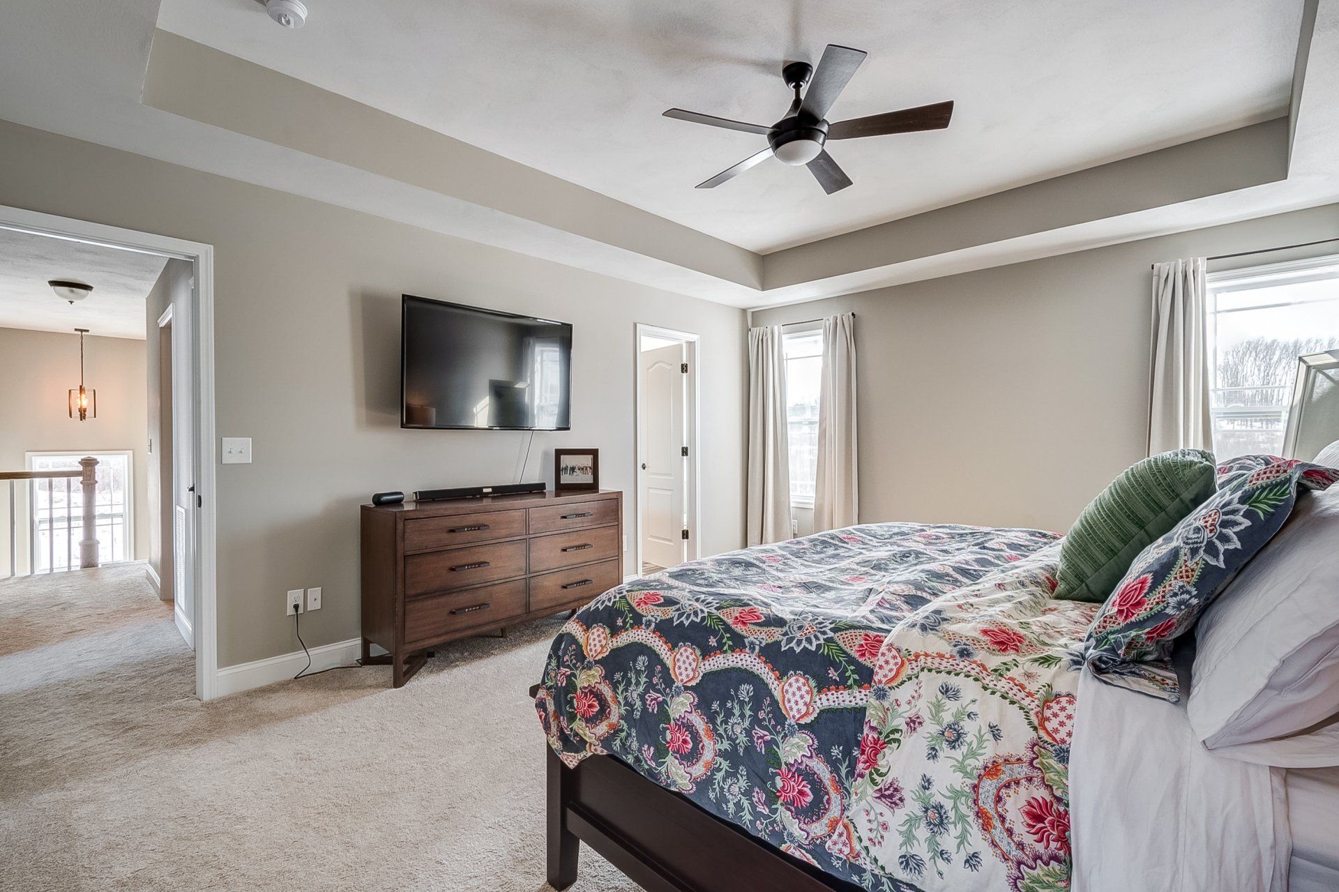 primary bedroom with recessed ceilings and ceiling fan