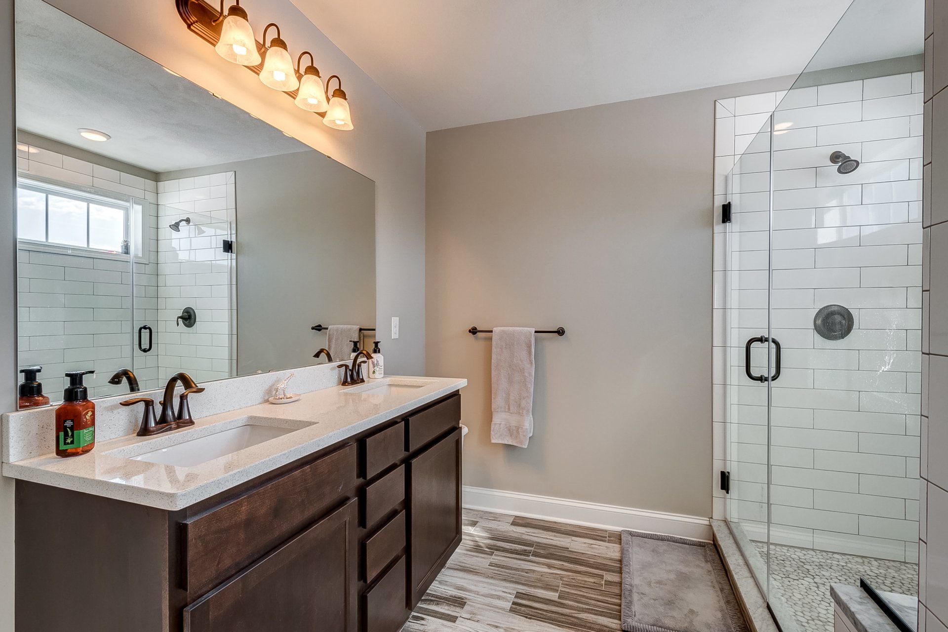 primary bathroom with double vanity and walk-in shower