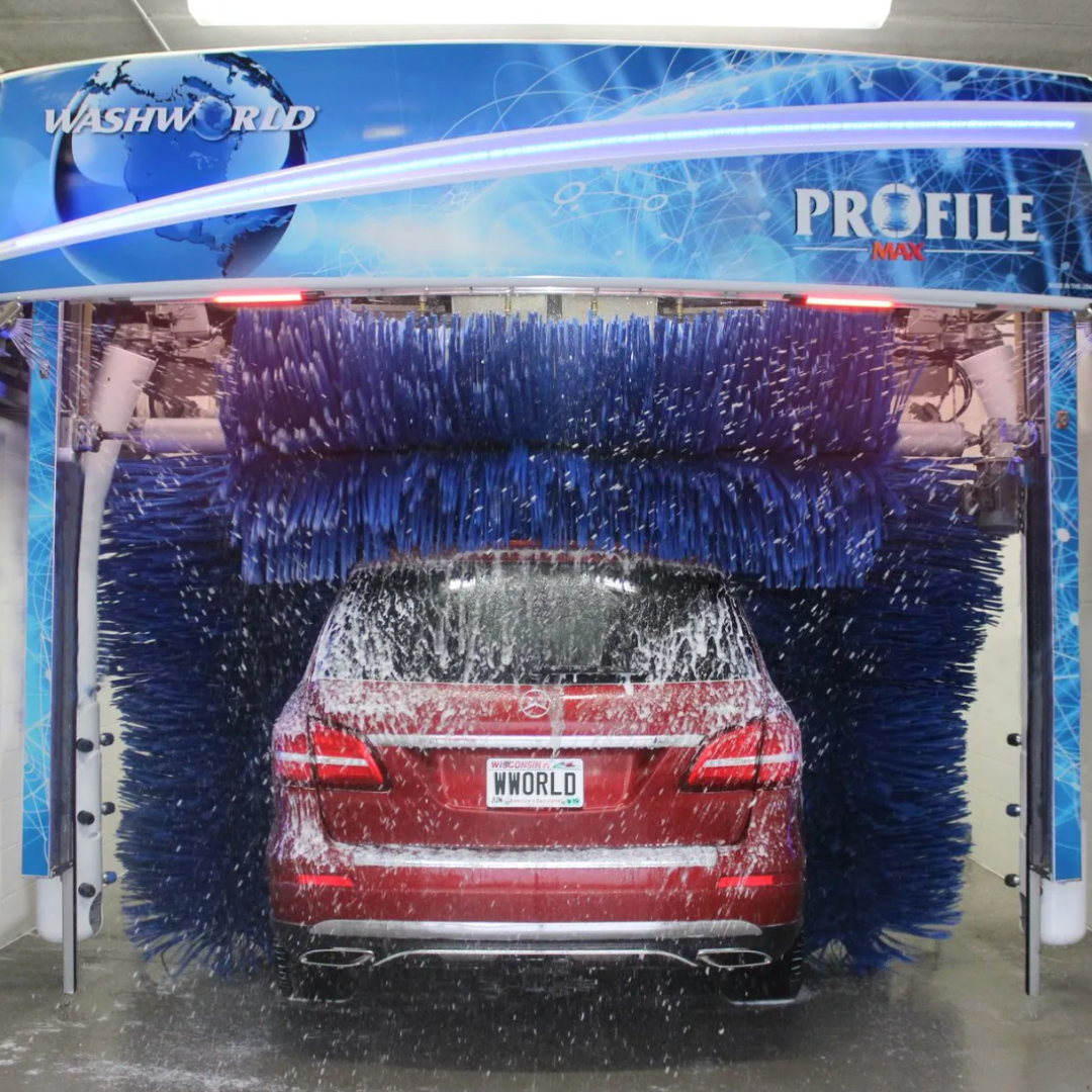 The image shows a red Mercedes-Benz vehicle being cleaned in an automated car wash.