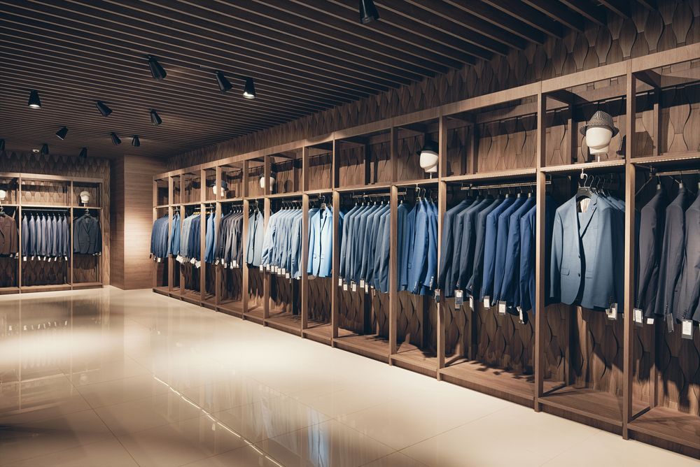 Boutique clothing store with rows of blue suits and wooden racks under warm lighting