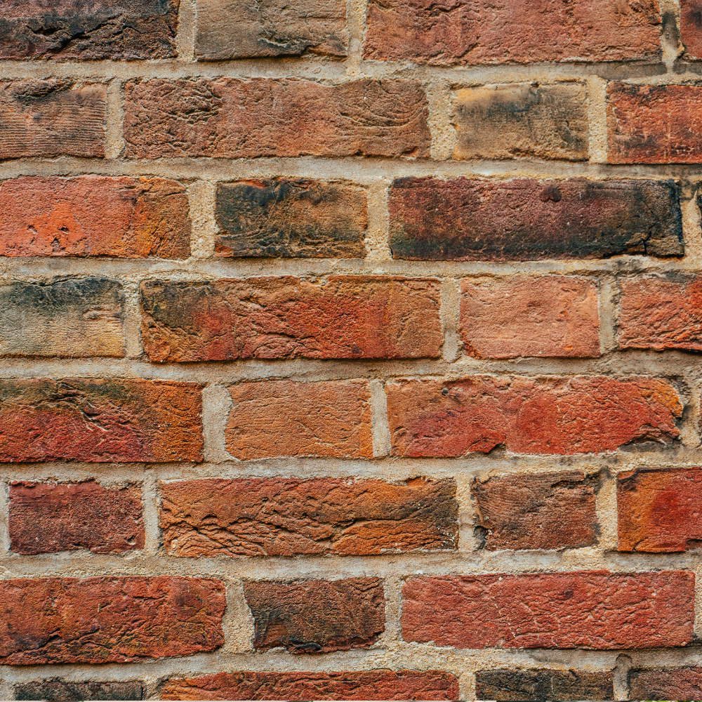 Red brick wall with weathered texture and light mortar.