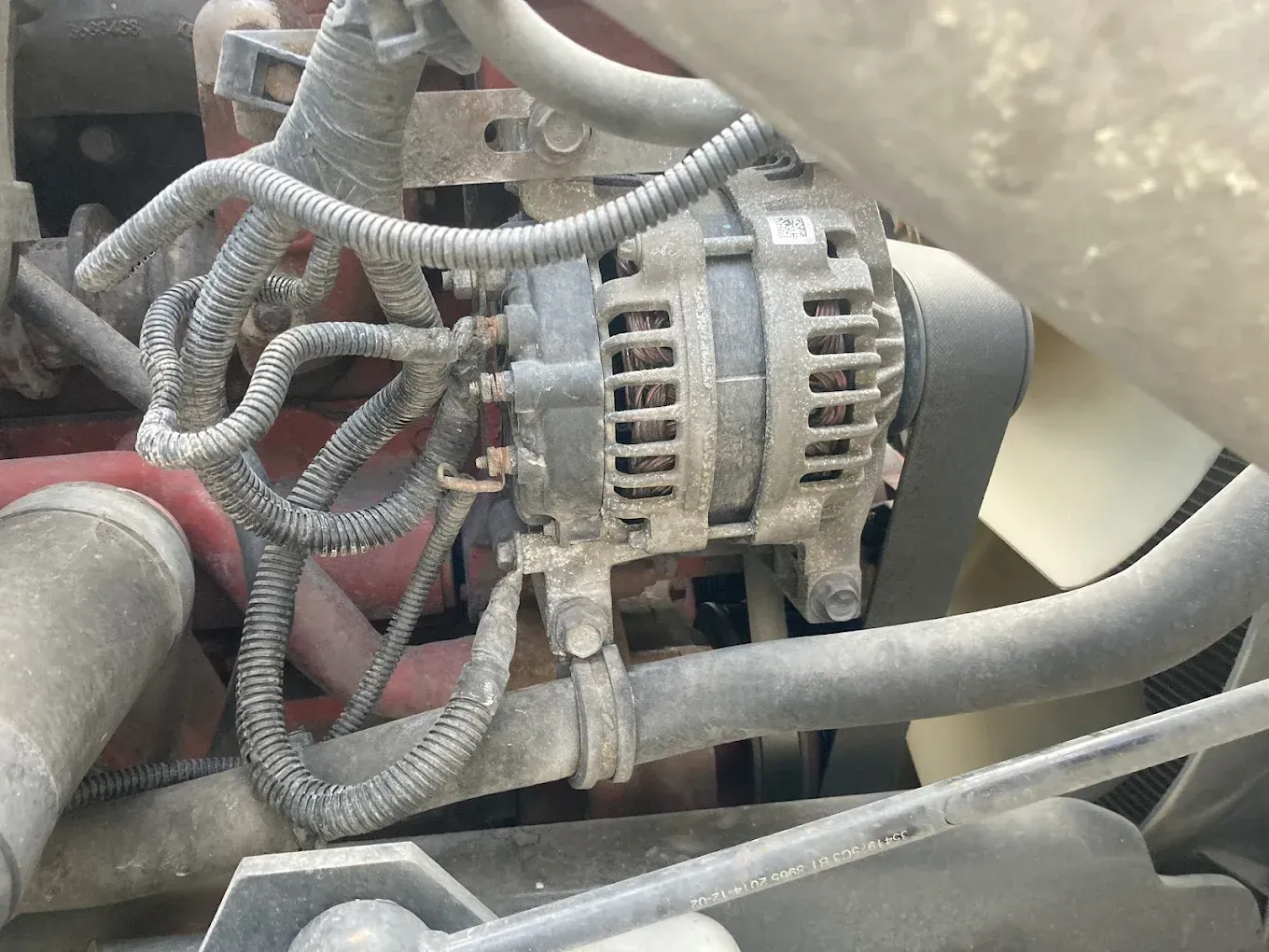 A close up of an alternator on a car engine
