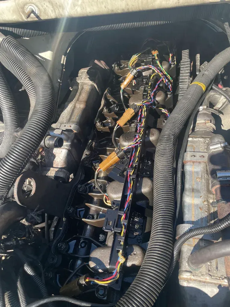 A close up of a car engine with a lot of wires coming out of it.