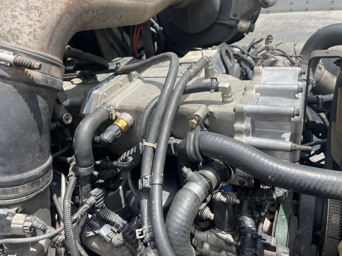 A close up of a car engine with a lot of hose attached to it