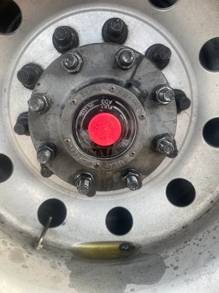 A close up of a truck wheel with a red cap on it.