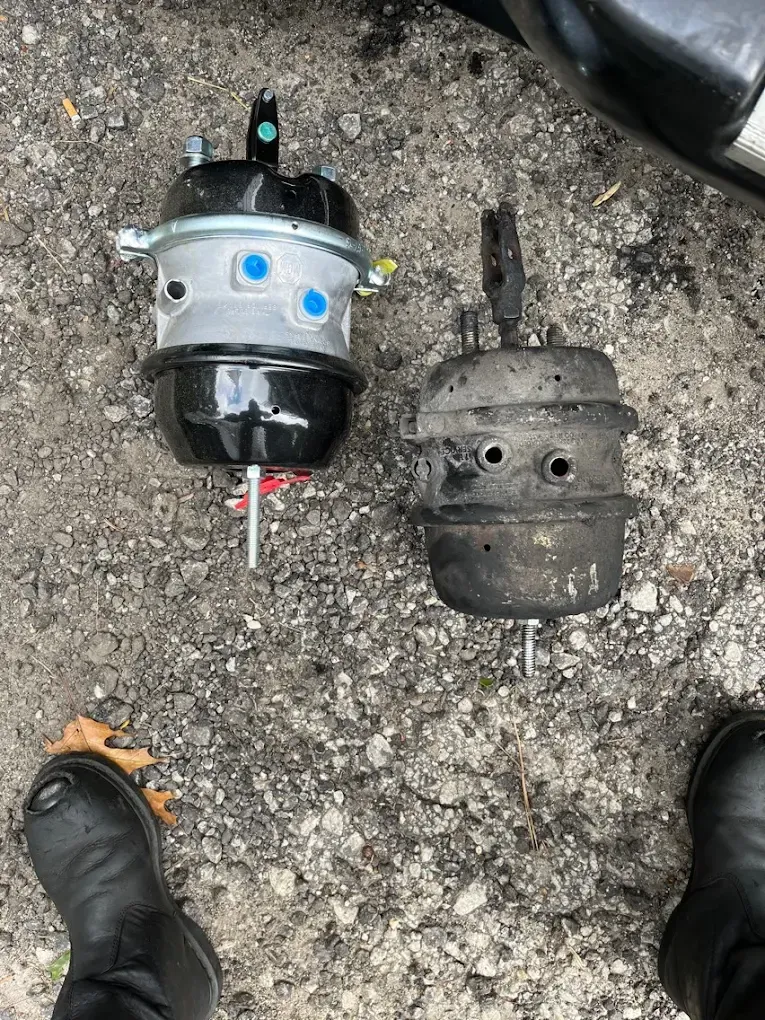 Two brake cylinders are sitting on the ground next to each other.