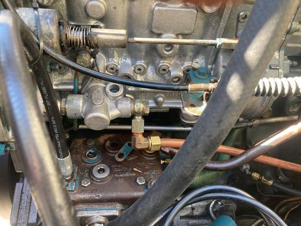 A close up of a tractor engine with a lot of wires coming out of it.