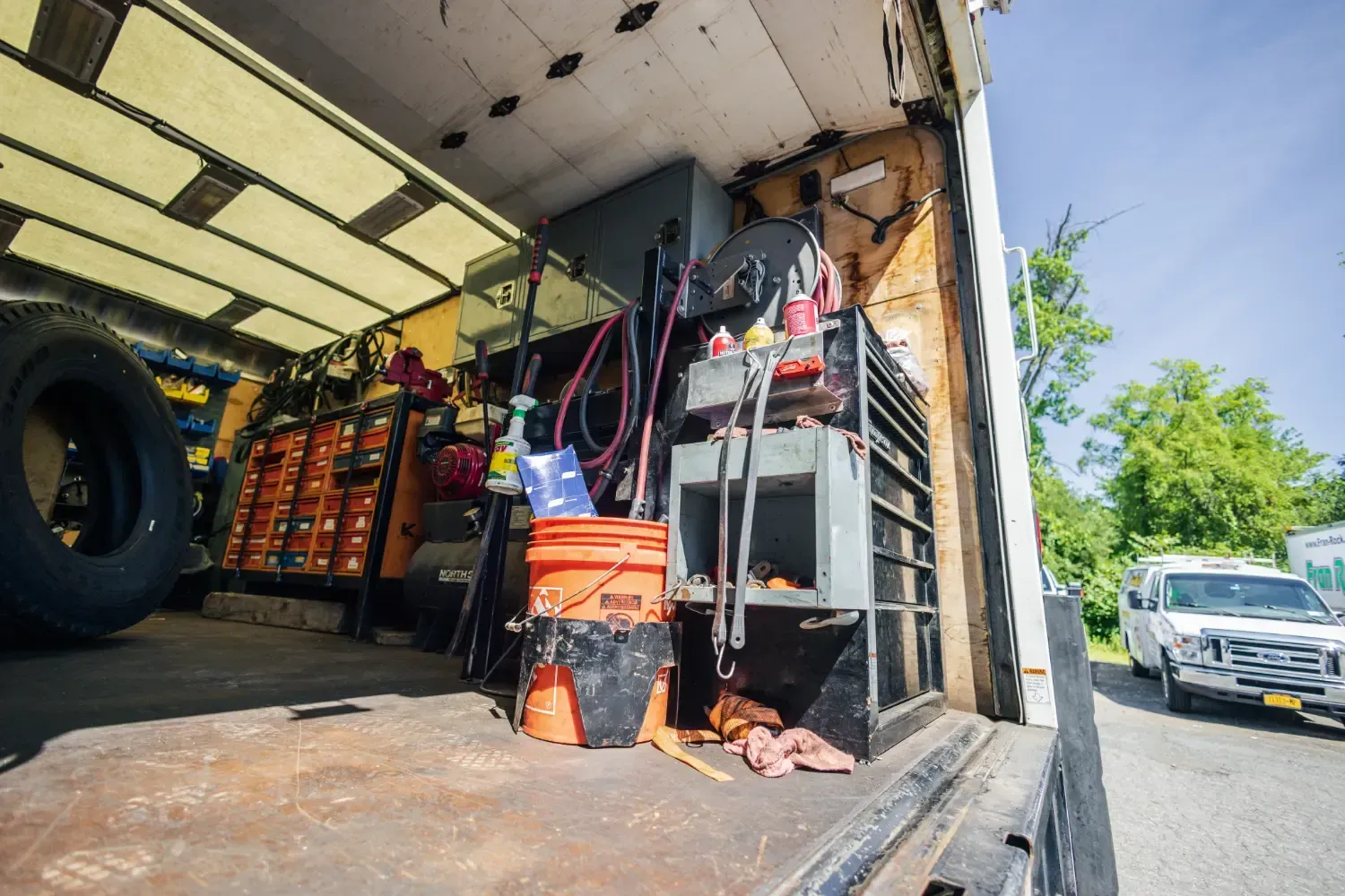 The back of a truck with a lot of tools in it.