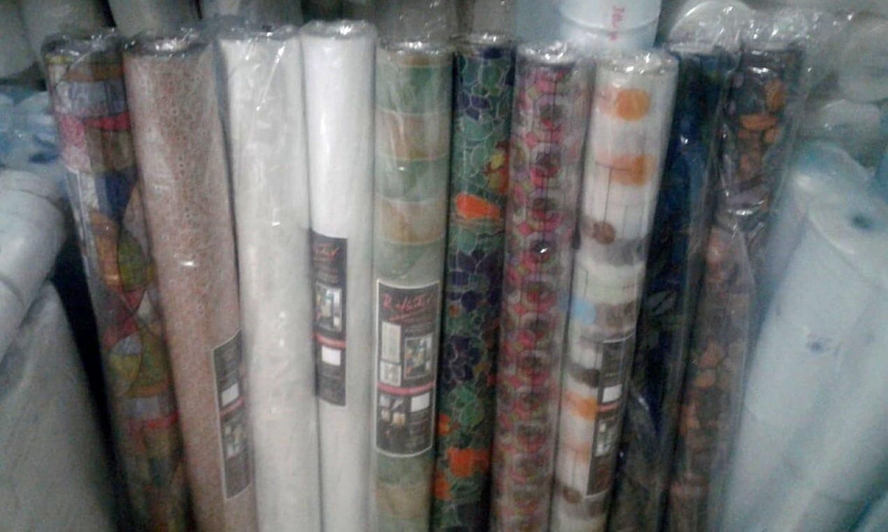 Un montón de rollos de papel de regalo están apilados uno encima del otro en una tienda.