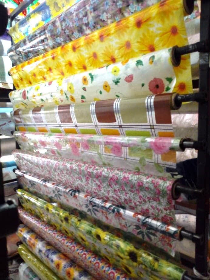 Los rollos de papel de regalo están alineados en un estante en una tienda.