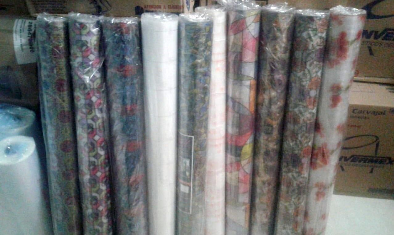 Un montón de rollos de papel de regalo están sobre una mesa.