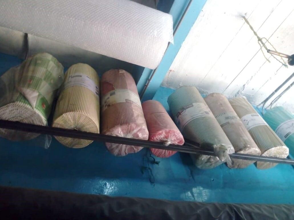 Un montón de rollos de tela están colgados en un estante.