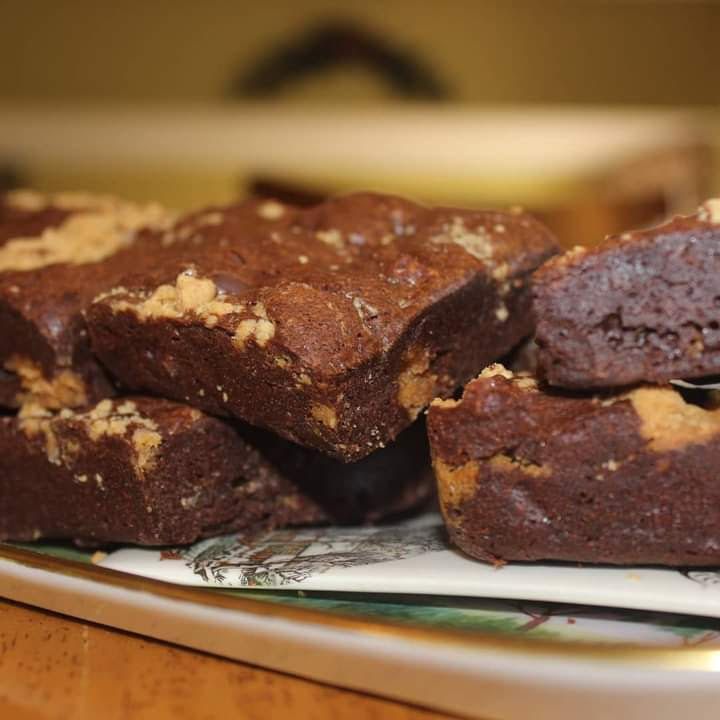 Brownies piled on a decorative tray, dark brown with light-brown crumbles on top.