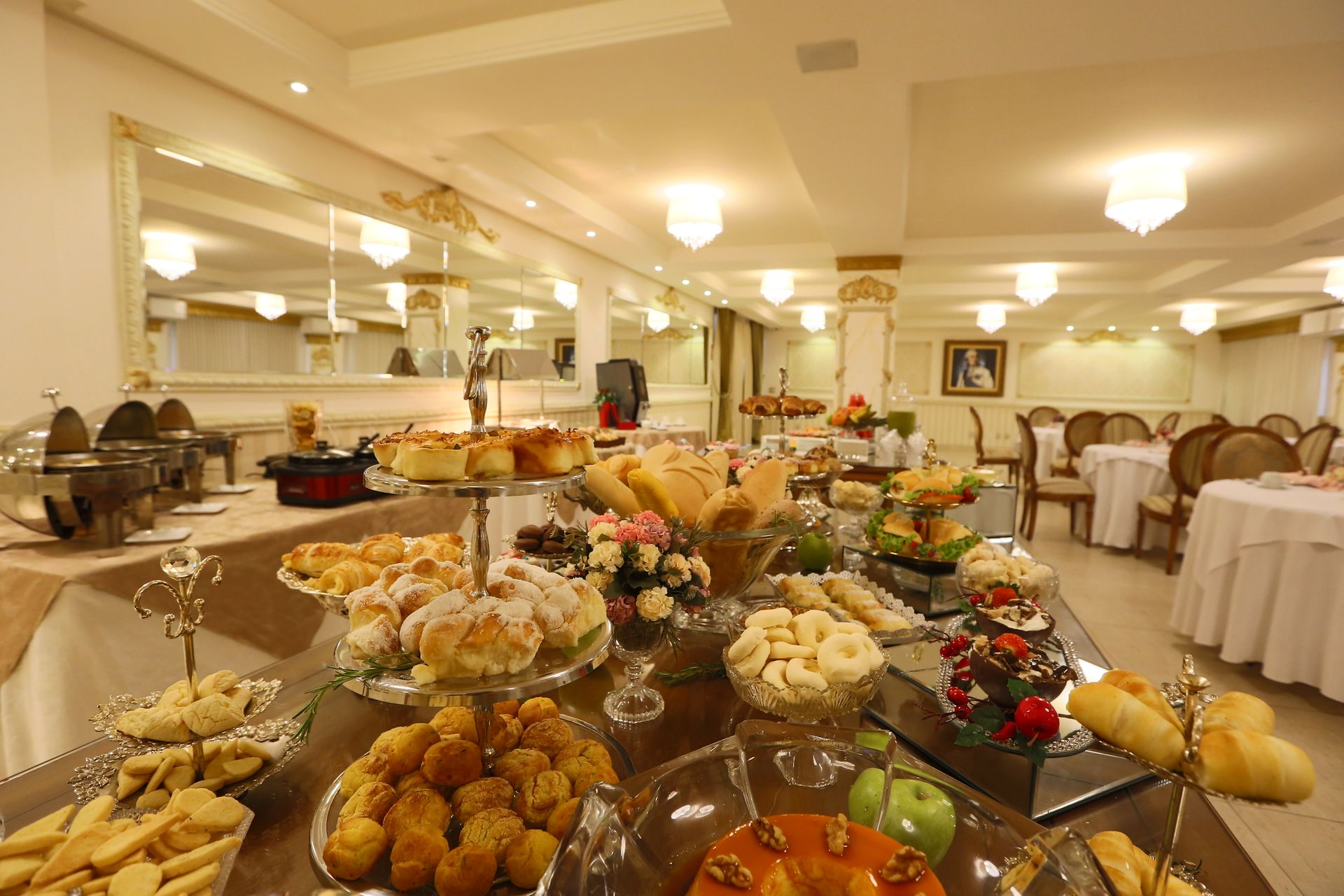 Um quarto de hotel com três camas e um espelho.