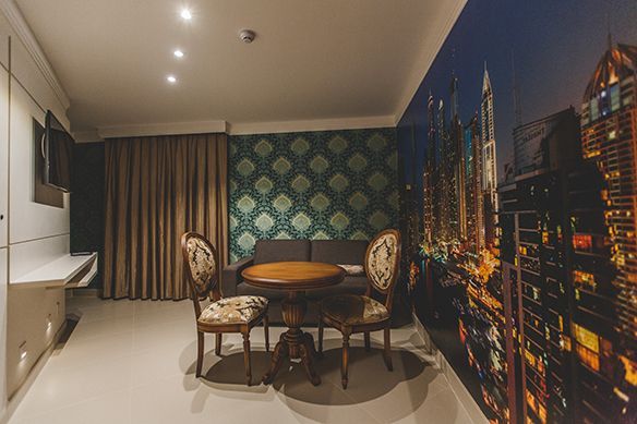 Um grande saguão de um hotel com um pufe redondo no meio.