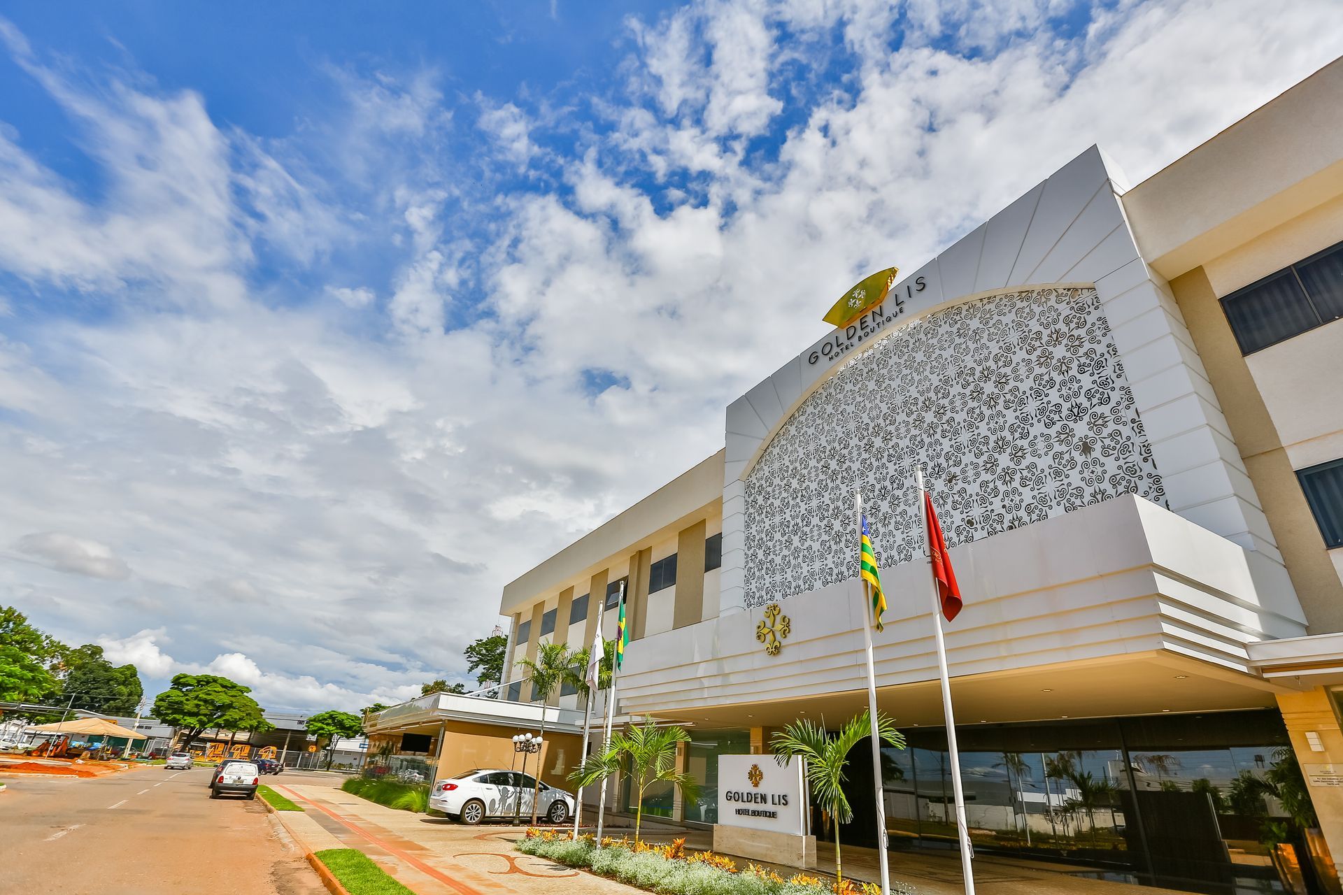 Uma vista aérea de um grande edifício branco com carros estacionados em frente a ele.