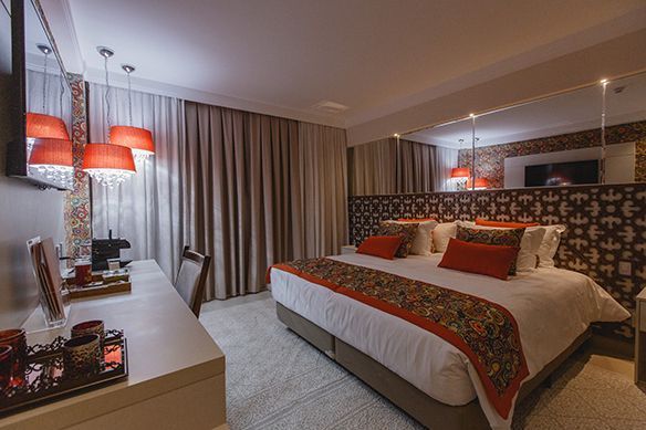 Um quarto de hotel com uma cama king size e um lustre.