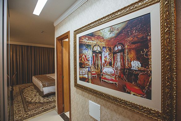 Um quarto de hotel com uma cama king size, escrivaninha e cadeira.