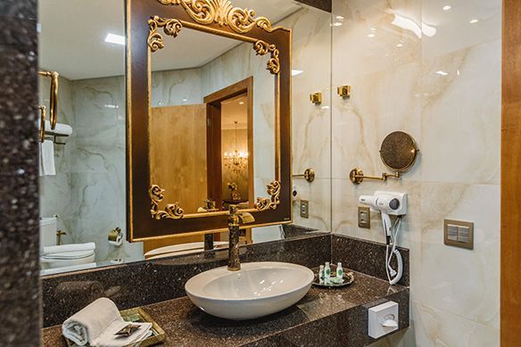 Um saguão de hotel com uma grande pintura na parede e um lustre pendurado no teto.