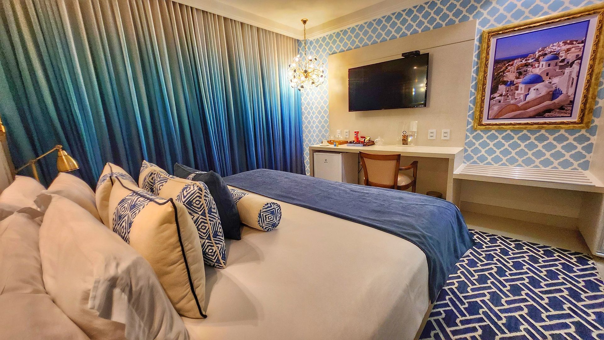 Um quarto de hotel com uma cama king size e um banco.