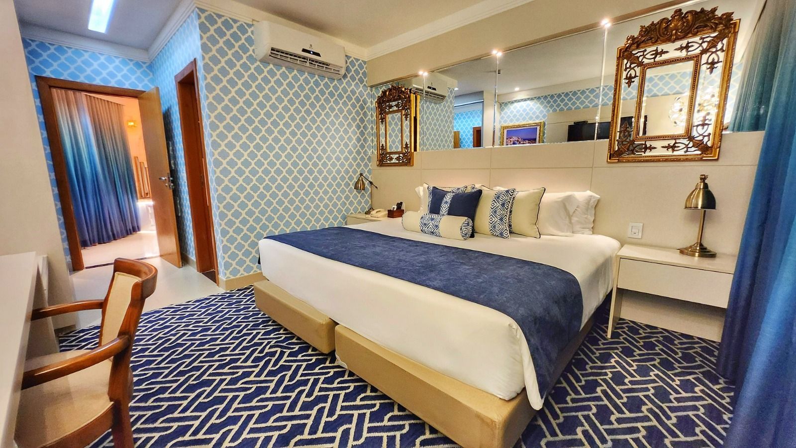 Um quarto de hotel com uma cama king size e uma escrivaninha.