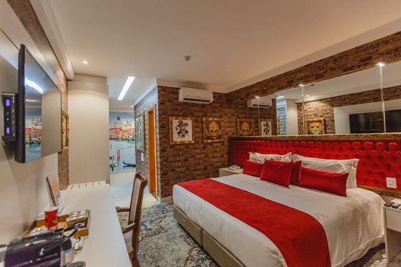 Um quarto de hotel com uma cama, escrivaninha, cadeira e uma barraca.