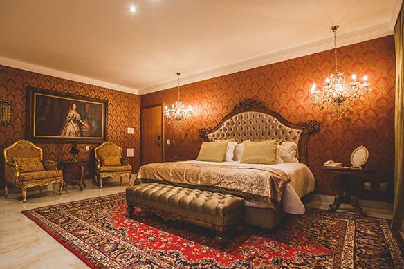 Um quarto de hotel com uma cama king size e travesseiros vermelhos.